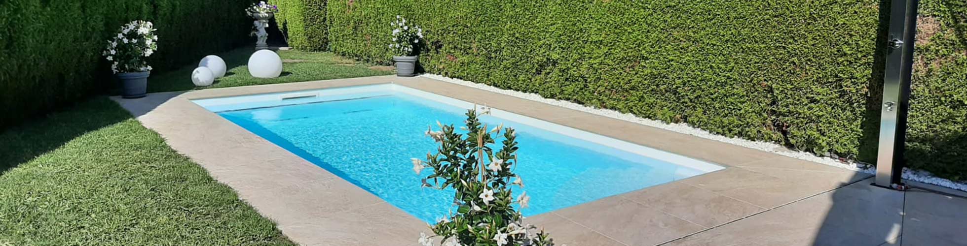 Pool in einem Garten mit Terassenplatten - gebaut von Poolbau Eckschlager in Salzburg